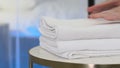 Chambermaid with stack of fresh towels in bedroom, closeup. Space for text