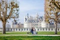 Chambord Castle, France. pair of lovers, couple sitting on bench on alley