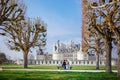 Chambord Castle, France. pair of lovers, couple sitting on bench on alley