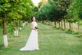 chaming young girl in a wedding dress posing for a photo in a green garden Royalty Free Stock Photo