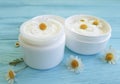 Chamomile flower, cosmetic ointment protection treatment sample skin cream product on a blue wooden background Royalty Free Stock Photo