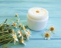 Chamomile flower, cosmetic extract treatment skin cream product on a blue wooden background Royalty Free Stock Photo