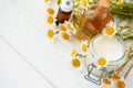Chamomile flowers and cosmetic bottles of essential oil and extract on white wooden background. Flat lay. Top view. Copy space Royalty Free Stock Photo