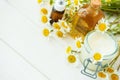 Chamomile flowers and cosmetic bottles of essential oil and extract on white wooden background. Flat lay. Top view. Copy space Royalty Free Stock Photo