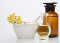 Mortar and bowl of dried healing herbs and bottles of homeopathic