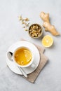 Chamomile herbal tea with lemon in a white cup on a light background with dry flowers and ginger. The concept of a healthy detox Royalty Free Stock Photo