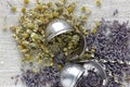Chamomile and lavender herb dried flower tea on linen textile with blossoms and buds nearby Royalty Free Stock Photo