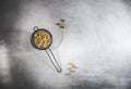 Chamomile tea loose flowers in a strainer on gray table