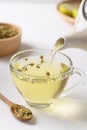 Chamomile tea in a teapot pouring into cup glass Royalty Free Stock Photo