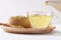 Chamomile tea in a teapot pouring into cup glass with dried chamomile flowers Royalty Free Stock Photo