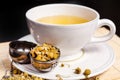 Chamomile tea in the white glass with opened tea strainer