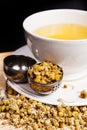 Chamomile tea in the white glass with opened tea strainer