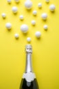 Champagne abstract made of bottle and styrofoam balls on yellow