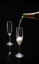 Champagne being poured into a glass on a black background Royalty Free Stock Photo