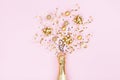 Champagne bottle with christmas decoration from confetti stars, golden balls and party streamers on pink background. Flat lay. Royalty Free Stock Photo