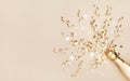 Champagne bottle with confetti stars and party streamers on gold festive background. Christmas, birthday or wedding. Flat lay Royalty Free Stock Photo