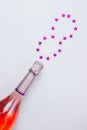 Champagne bottle with confetti stars on white background Royalty Free Stock Photo