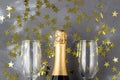 Champagne bottle and glasses with gold confetti stars. Concept for christmas, birthday or wedding Royalty Free Stock Photo