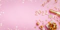 Champagne bottle, golden gift or present box, 2021 number and confetti on pink background top view. Christmas and New Year card. Royalty Free Stock Photo