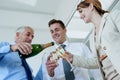 Champagne, bottle or happy business people in office party in celebration of target or success. Pour, glass low angle or Royalty Free Stock Photo