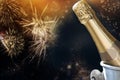 champagne bottle ready to bring in the New Year - holiday lights and fireworks in the background Royalty Free Stock Photo