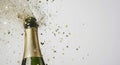 champagne bottle spewing champagne dust on a white background