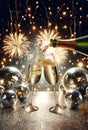 Champagne bottle with two flutes over sparkling fireworks background. Party decoration disco balls and golden glitter Royalty Free Stock Photo