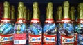 Champagne bottles with sweets and chocolate Bounty, Snickers, on a supermarket shelf. Creative holiday gift wrapping ideas. Celebr