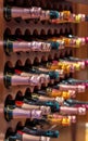 Champagne or cava bottles of different metallic colored labels lined up and stacked on wooden shelves of a wine rack in a gourmet Royalty Free Stock Photo