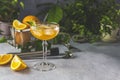 Champagne coupe glass of refreshing orange cocktail with ice served on gray table surface surround of orange fruit and different Royalty Free Stock Photo