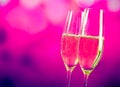 Champagne flutes with gold bubbles on blue and violet tint light background Royalty Free Stock Photo