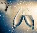 Champagne flutes with golden bubbles on blue and golden light bokeh background Royalty Free Stock Photo