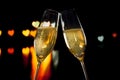 Champagne flutes with golden bubbles on hearts bokeh background Royalty Free Stock Photo