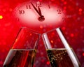 Champagne flutes with golden bubbles on red light bokeh background Royalty Free Stock Photo