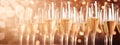 Champagne flutes with sparkling wine on golden bokeh lights backdrop. Peach fuzz Color of Year 2024