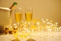 Champagne flutes on table decorated with streamer and gold confetti. Royalty Free Stock Photo