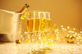 Champagne flutes on table decorated with streamer and gold confetti. Royalty Free Stock Photo