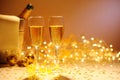 Champagne flutes on table decorated with streamer and gold confetti. Royalty Free Stock Photo