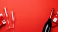 Champagne and gift: Celebratory duo on a red background with text space Royalty Free Stock Photo