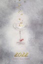Champagne glass and gold confetti on a gray textured background with the inscription 2022, happy new year