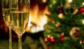 Champagne glasses on the background of Christmas tree and fireplace. New year celebration. Champagne glass close up. Royalty Free Stock Photo