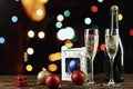 champagne in glasses and in a bottle and toys on the Christmas tree on the background of bokeh. Royalty Free Stock Photo