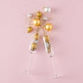 Champagne glasses with christmas decorations explosion of gold, silver christmas tree balls and sequins Royalty Free Stock Photo