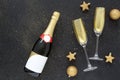 Champagne glasses with golden confetti and a bottle of champagne on black background. Christmas card. Celebrate party concept. Royalty Free Stock Photo