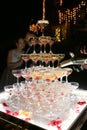 Champagne glasses standing in a tower at the wedding party. Champagne glass pyramid. Pyramid of glasses of wine champagne tower