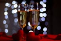 Champagne in glasses of two in romantic valentine concept with heart shaped fabric on red and light bokeh background Royalty Free Stock Photo