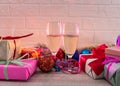 Champagne in glasses on wooden table with colorful Christmas presents Royalty Free Stock Photo