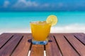 Champagne Mango-lime aqua fresca cocktail on wooden table ocean background at the beach