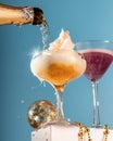 Champagne pouring in two glasses on blue background. Festive champagne and cotton candy cocktails, cheers concept Royalty Free Stock Photo