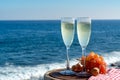 Champagne, prosecco or cava served with pink grape in two glasses on outside terrace with sea view Royalty Free Stock Photo